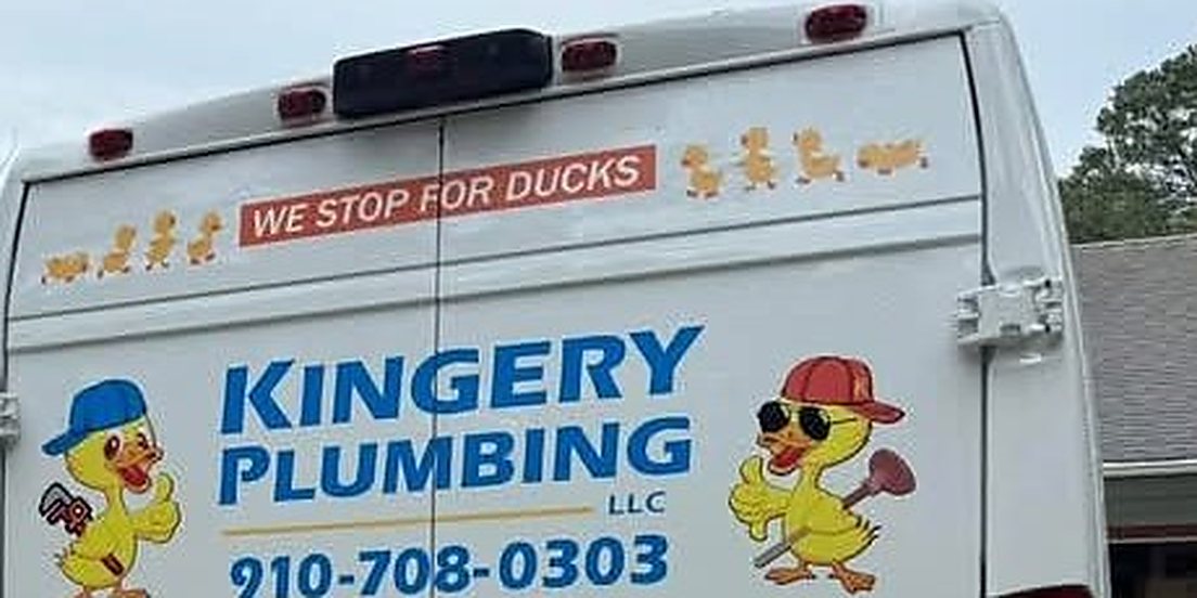 Close-up of a Kingery Plumbing van's rear door: a red decal reading "WE STOP FOR DUCKS" with a row of duckling stickers above the company name.